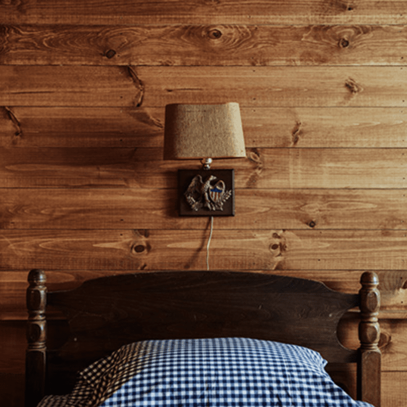 带木床和印花床单的木镶板卧室