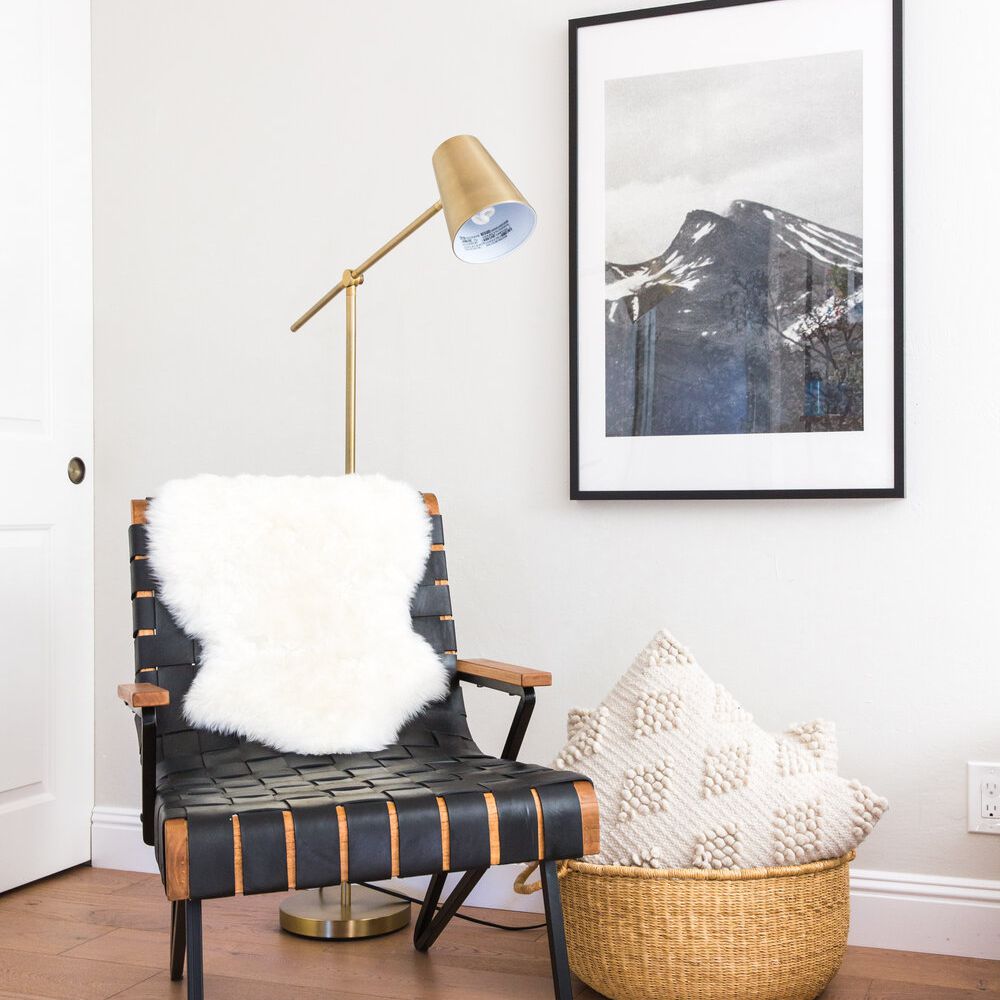 卧室的角落装饰着一个装满枕头的编织篮子