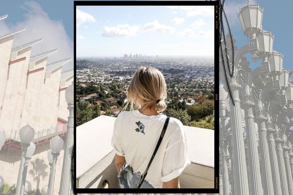 一个女孩越过一堵墙看洛杉矶城。