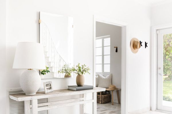 与镜子和被编织地毯的明亮和晴朗的白色入口。