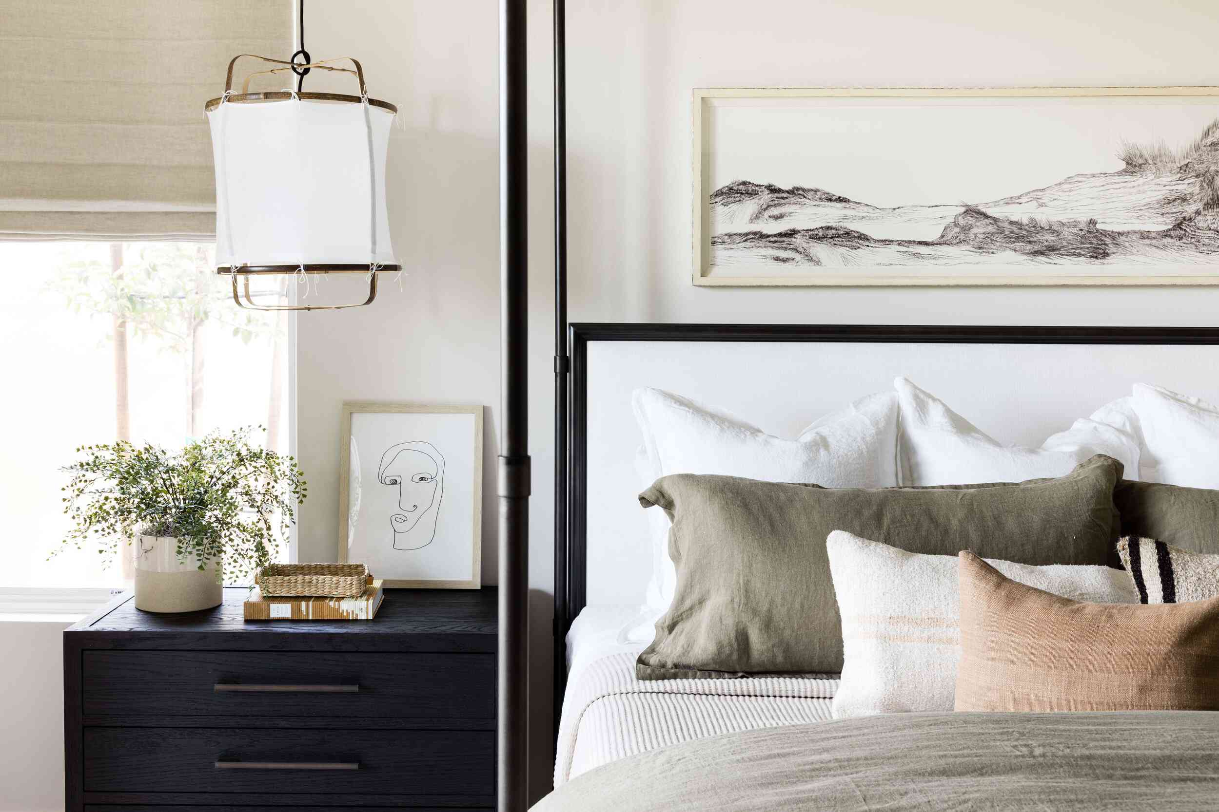 一间带有黑色顶篷床的中性卧室