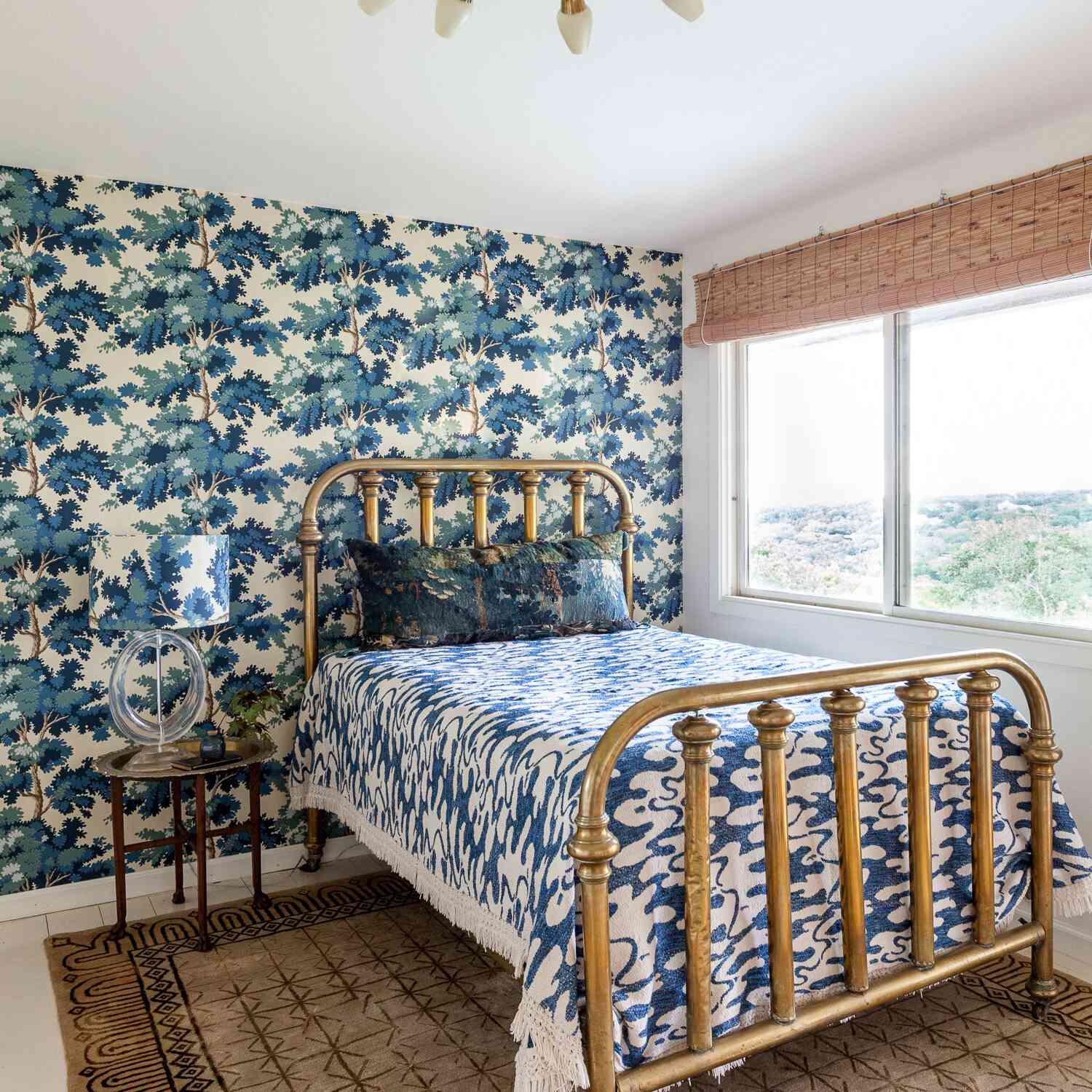 一间带蓝色印刷壁纸和配套灯的卧室