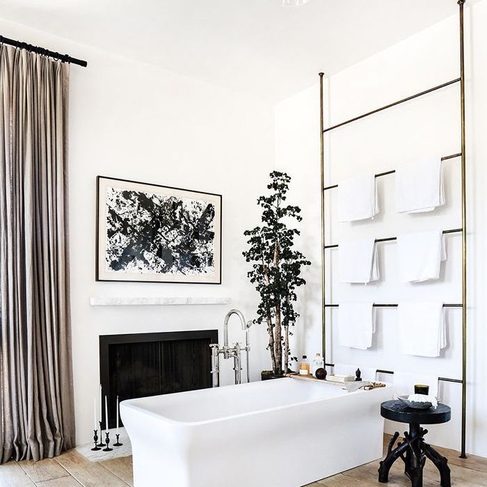 在一个超大的浴室中央的一个方形浴缸，带有一个壁炉