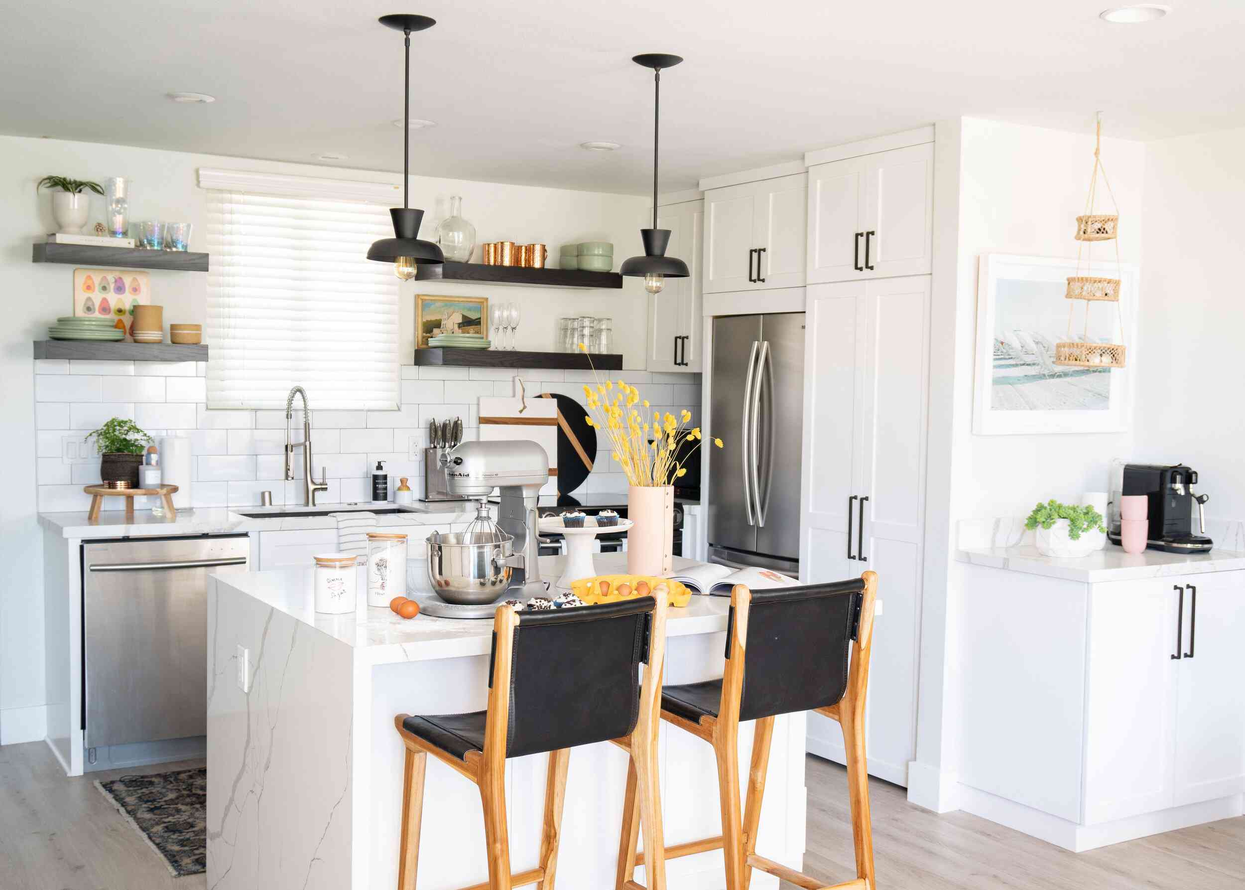 一个白色的小厨房，颜色协调的厨房用具和几个装饰黑色的口音