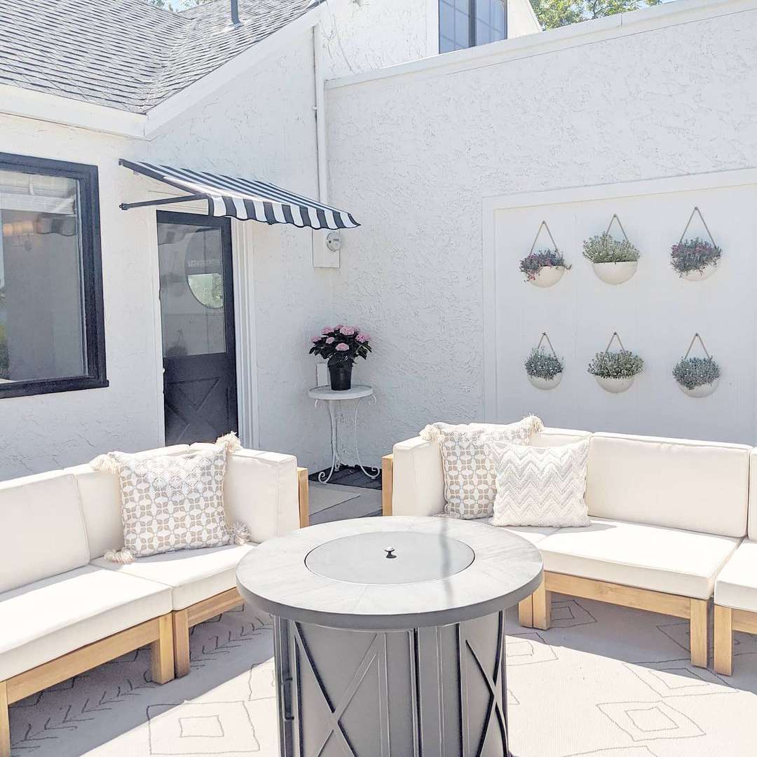 阳光明媚的后院有沙发和火塘。