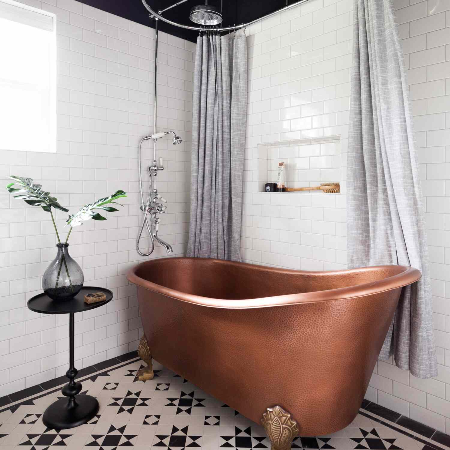 带玫瑰金钳浴缸和灰色淋浴窗帘的浴室