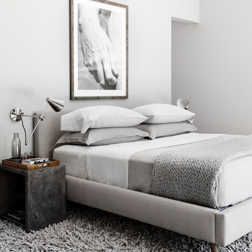 浅灰色的卧室，有一张石板灰色的床头柜