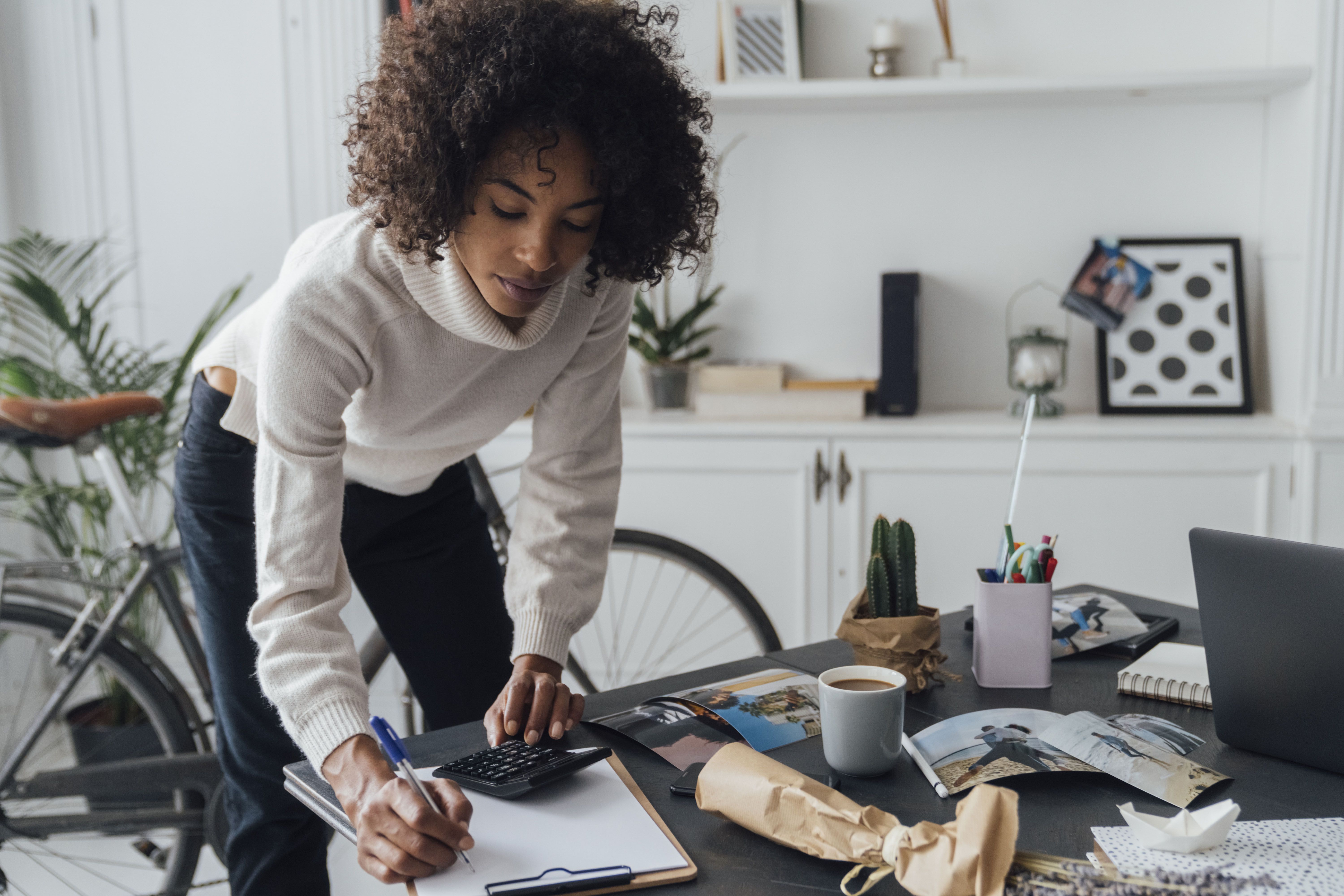 女人使用计算器和写笔记