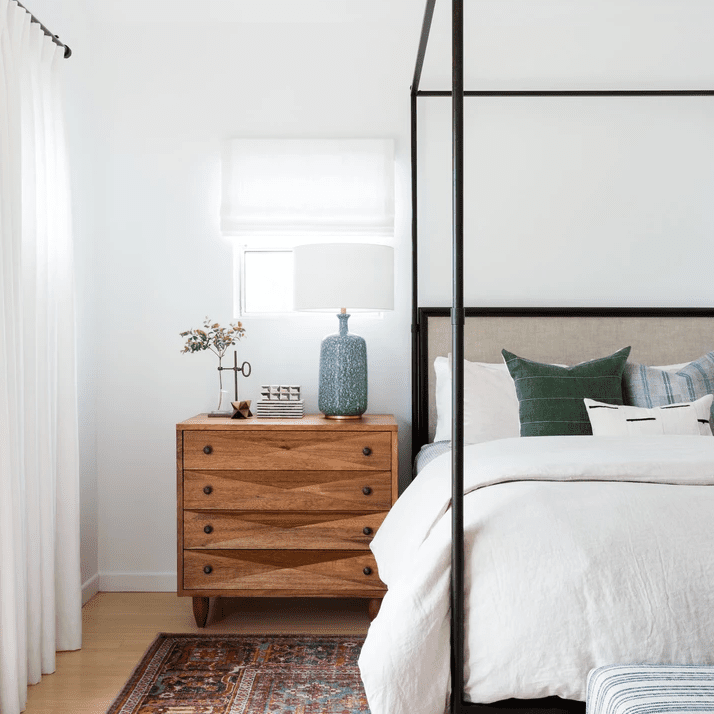 一个色彩鲜艳的房间，红色的地毯和黑色的顶篷床