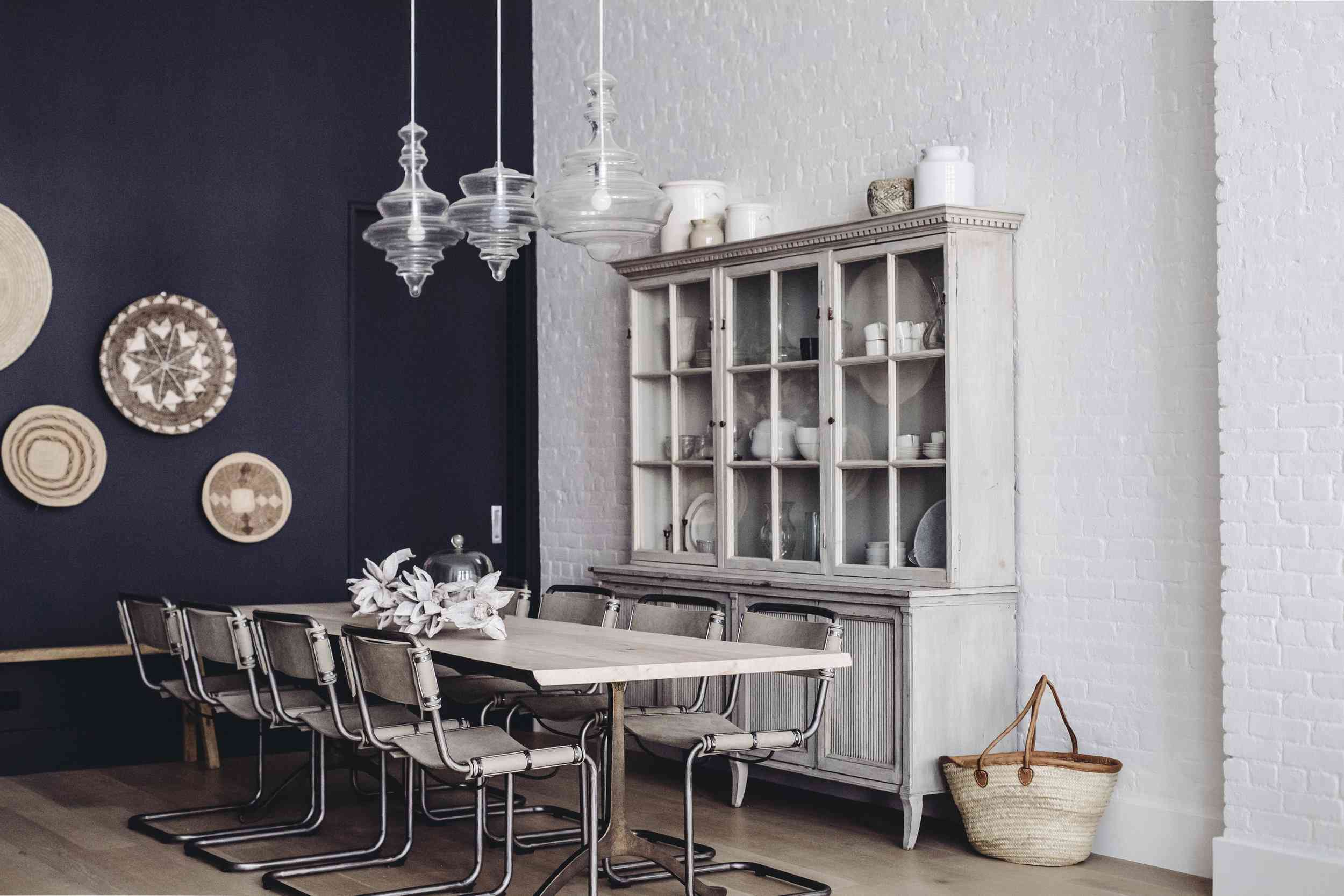 一个海军和白色用餐室点燃了三个协调（但略微不同）的吊灯