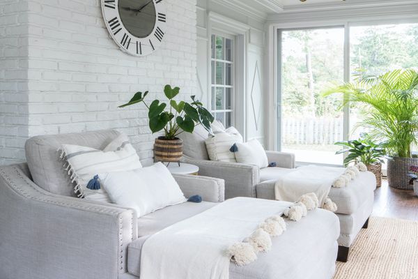 阳光房，白色砖墙，灰色躺椅休息室，和植物。