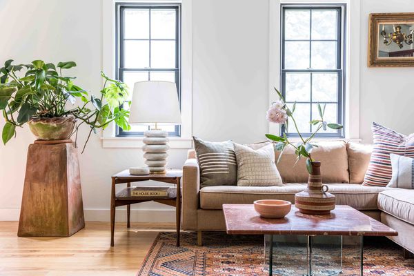 柔软的中性客厅有质朴的灯和大型植物。