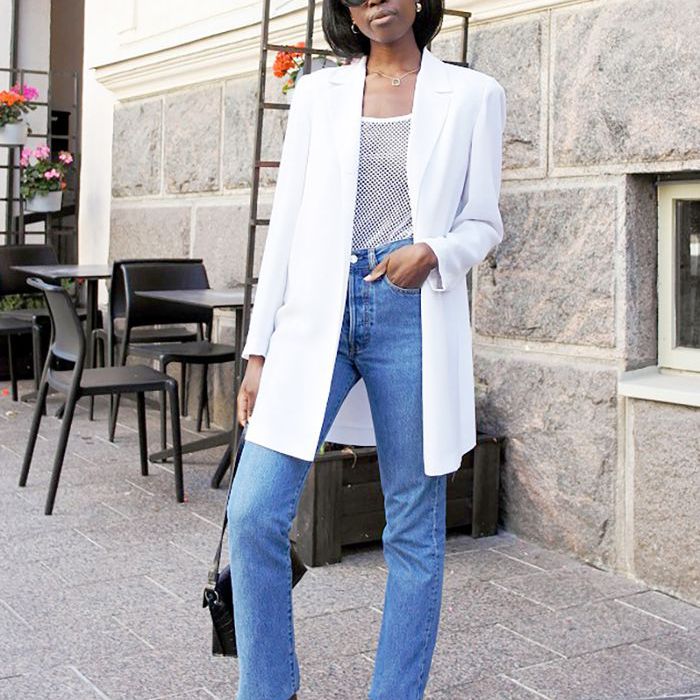 在牛仔裤的妇女和一个白色夹克