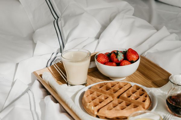 在床上吃早餐“class=