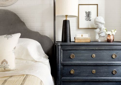 Blue nightstand with decorative objects.