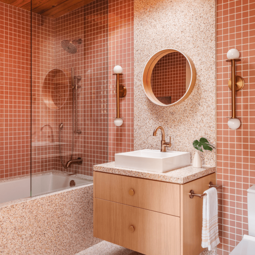 一间铺着粉色瓷砖和粉色水磨石板的单色浴室