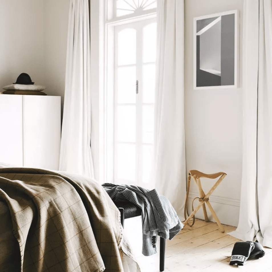 地板长度的白色窗帘构成了卧室的一扇窗户
