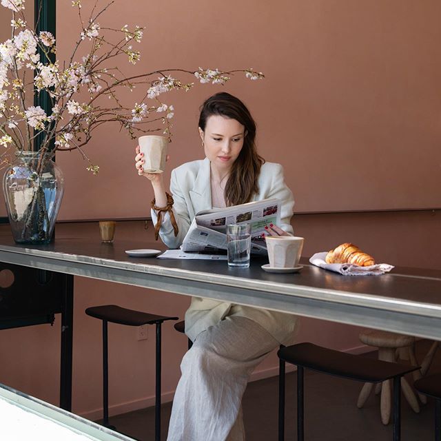 一名女性为了逃避社交媒体而不看报纸，而不使用智能手机。