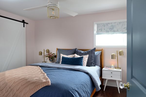 卧室配有粉红色的墙壁和蓝色寝具