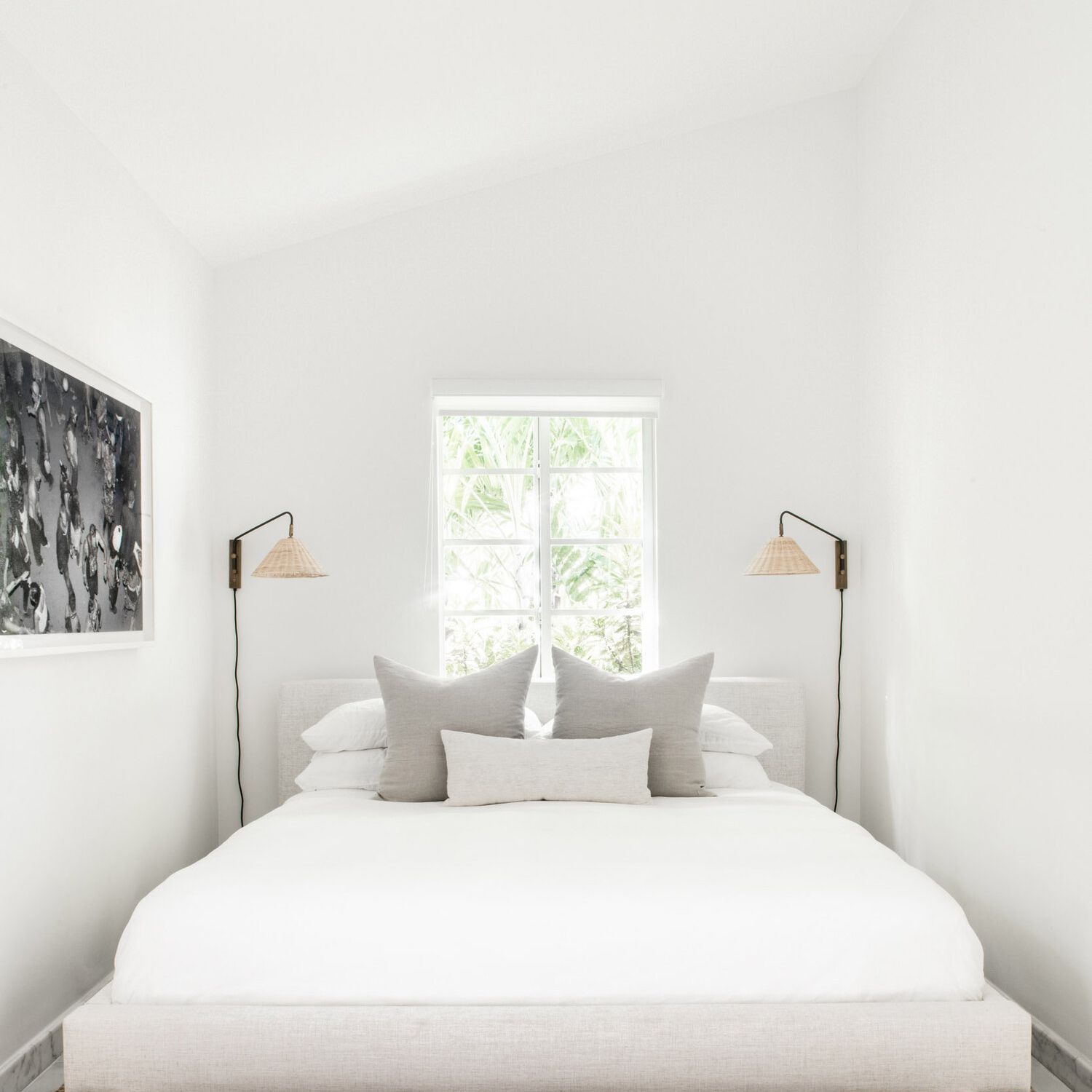 一间极简主义风格的卧室，配有两个编织壁灯