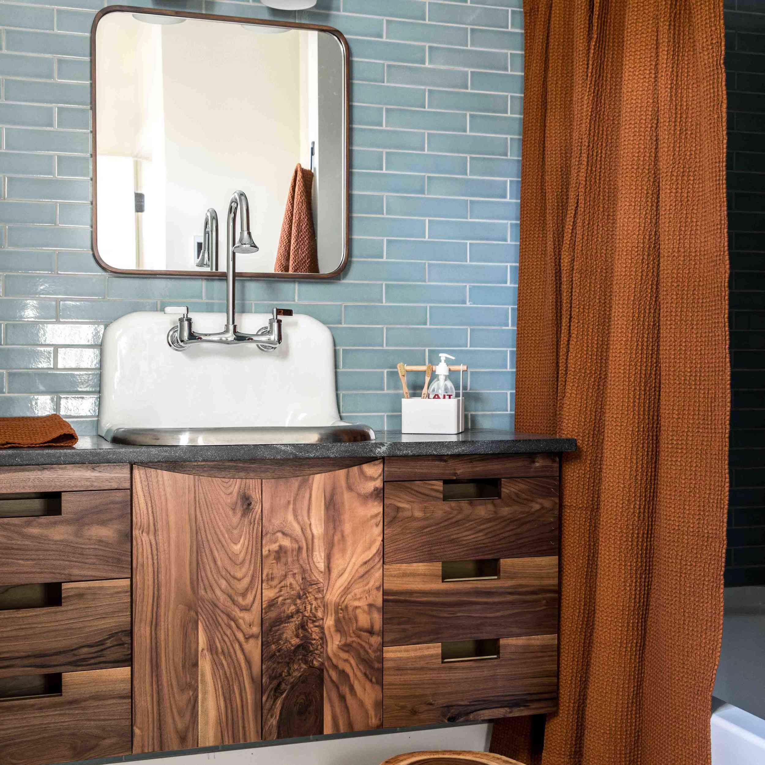 一间铺着瓷砖的浴室，带有内置后挡板的白色水槽