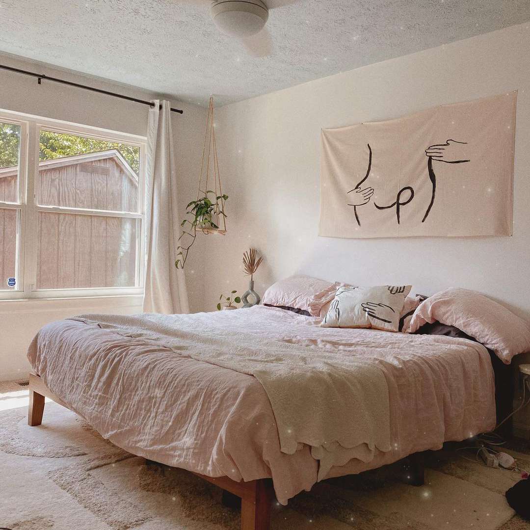 带粉红色床单和吊厂的中性卧室。