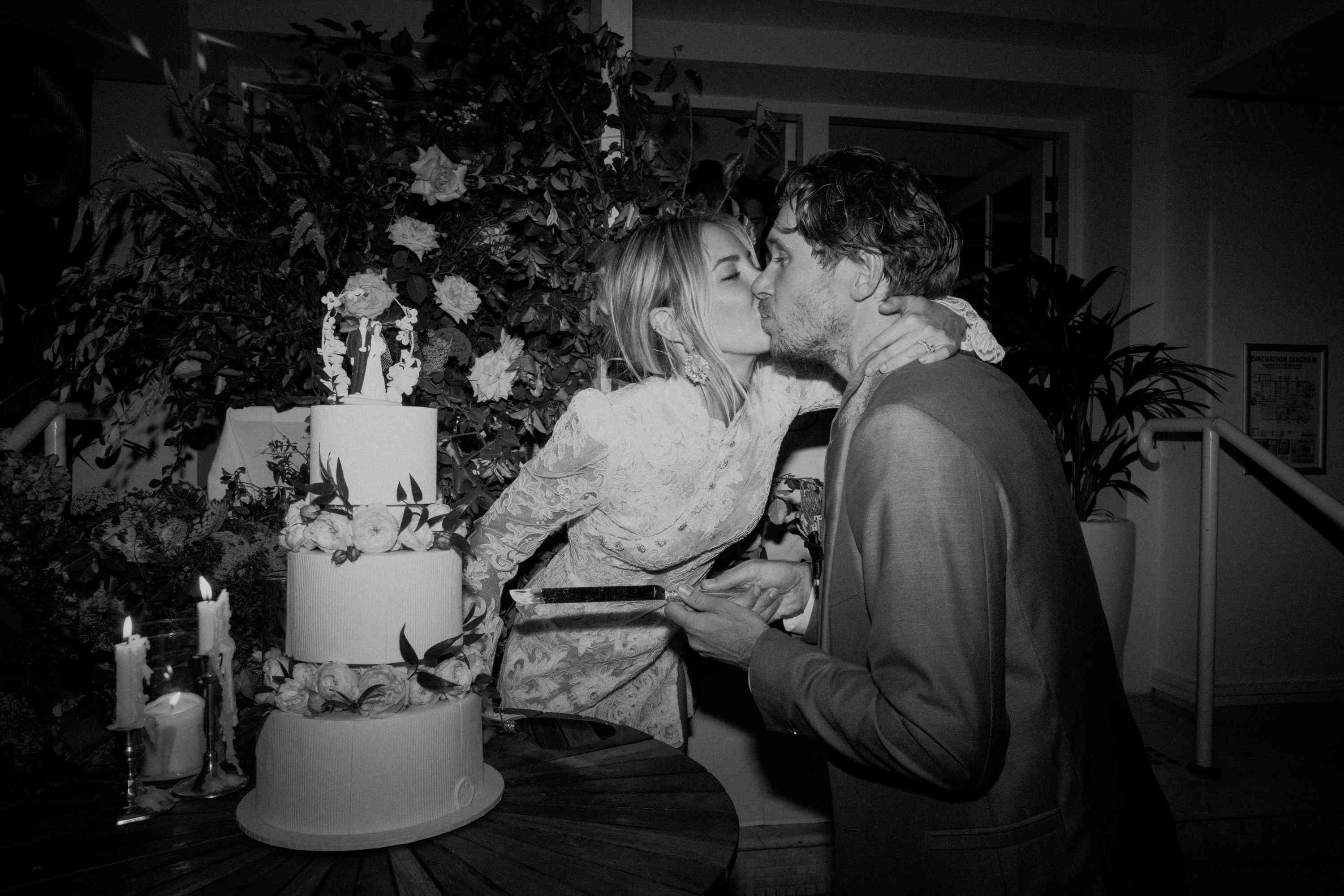 新娘和新郎亲吻和切结婚蛋糕