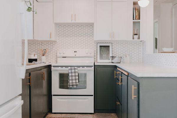 现代厨房有白色橱柜，六角形瓷砖背板