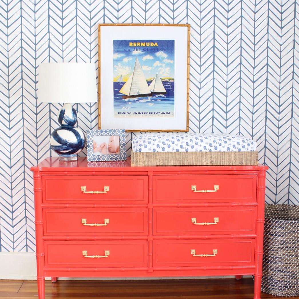 明亮的橙色梳妆台和古董百慕大的海报挂在上面。