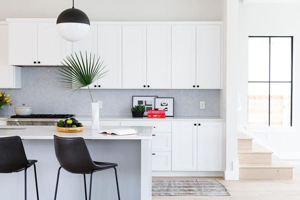 有棕榈叶装饰的明亮的白色厨房。