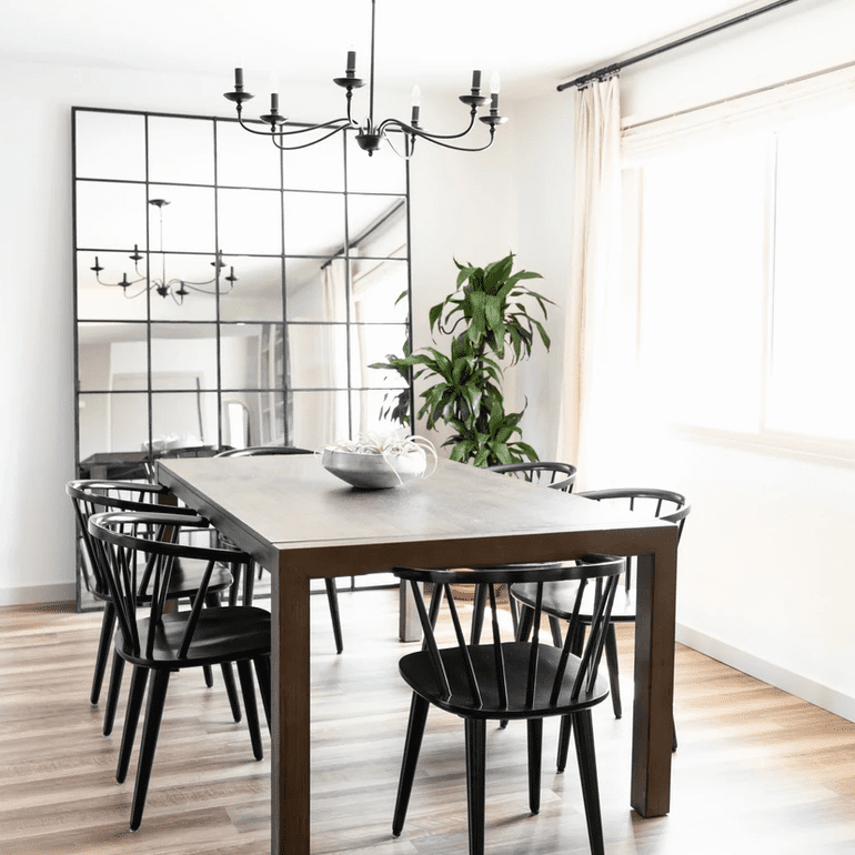 带黑色枝形吊灯的餐厅，配套黑色镜子和匹配的黑色椅子