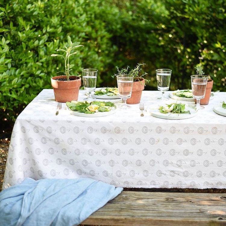 在户外的桌子上放置布料和玻璃器皿。