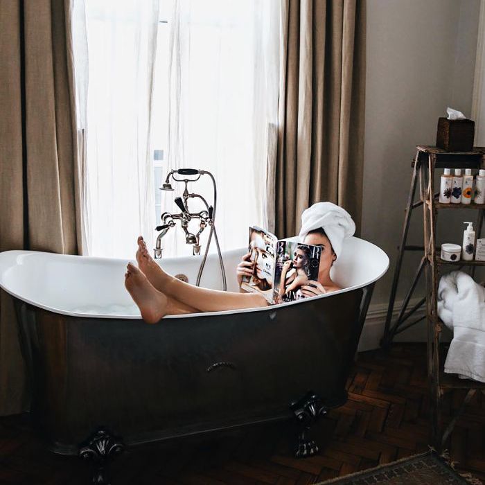 一个女人在洗澡读一本杂志