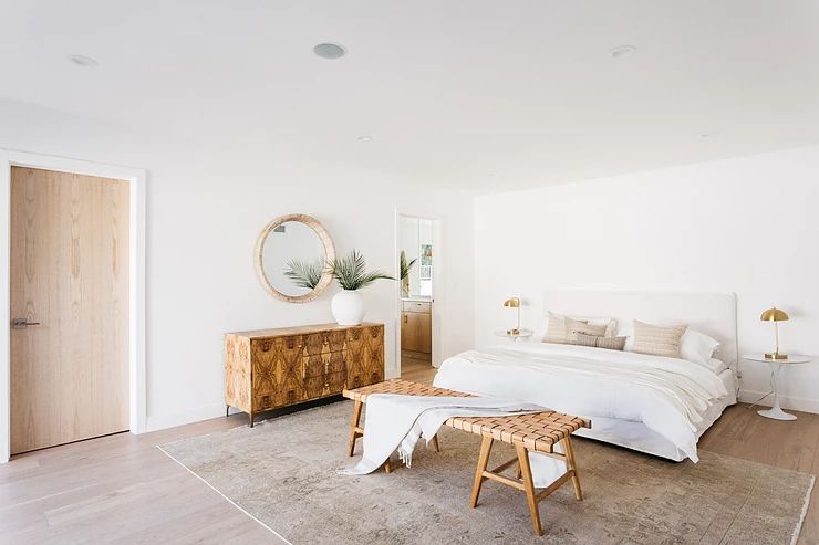 海滩中性卧室与长凳在床脚。