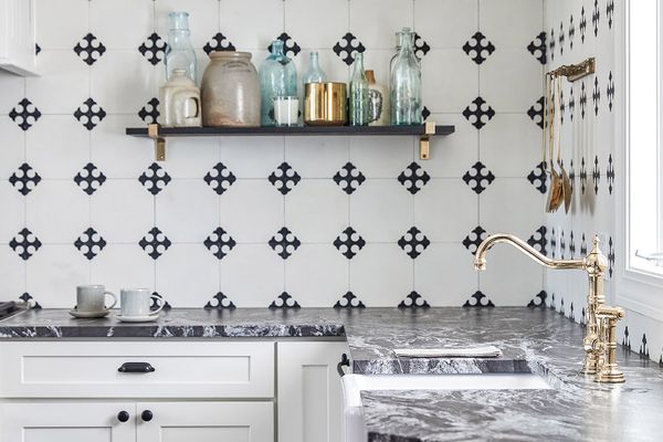 一个黑色和白色瓷砖背板和醒目的大理石台面的厨房