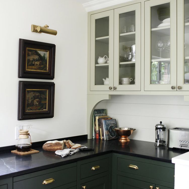 厨房里有深绿色的橱柜和浅绿色的高橱柜