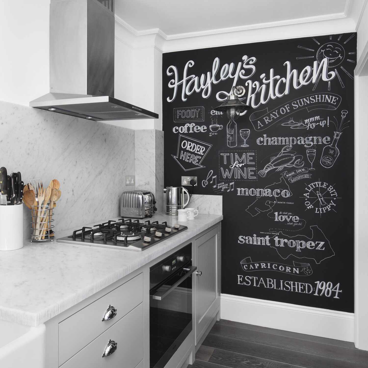 厨房里有浅灰色的橱柜、大理石台面和木炭地板