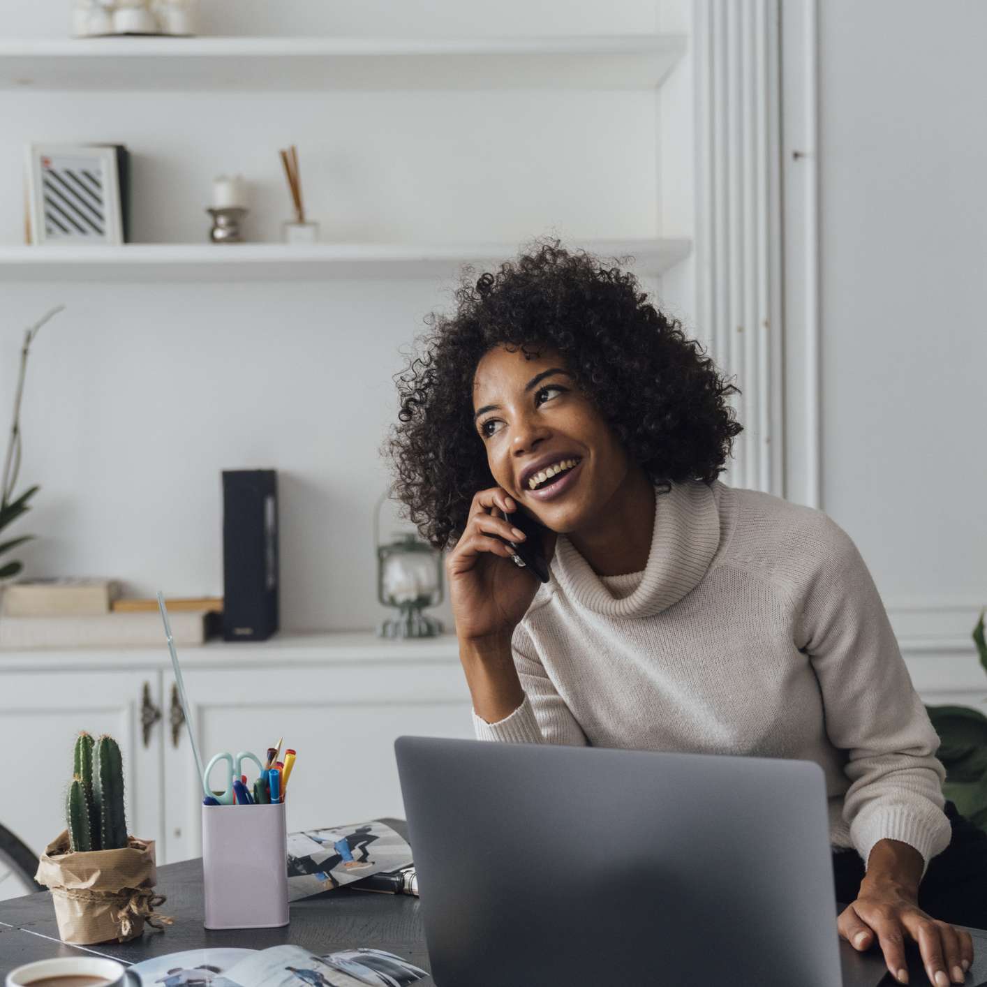 一位女士在电话里面带微笑，看起来很乐观。