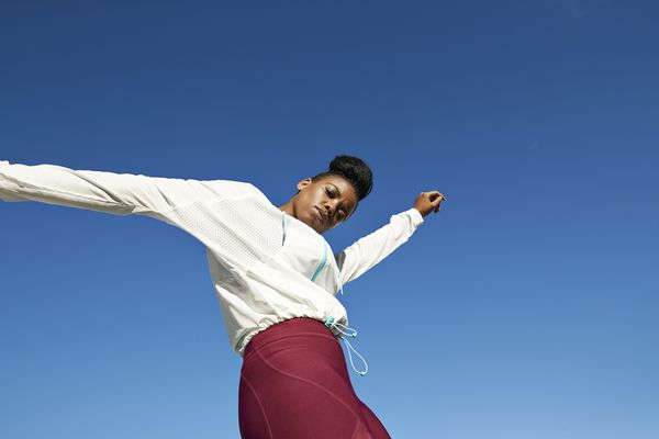 穿着运动服的年轻女子在晴朗的天空下