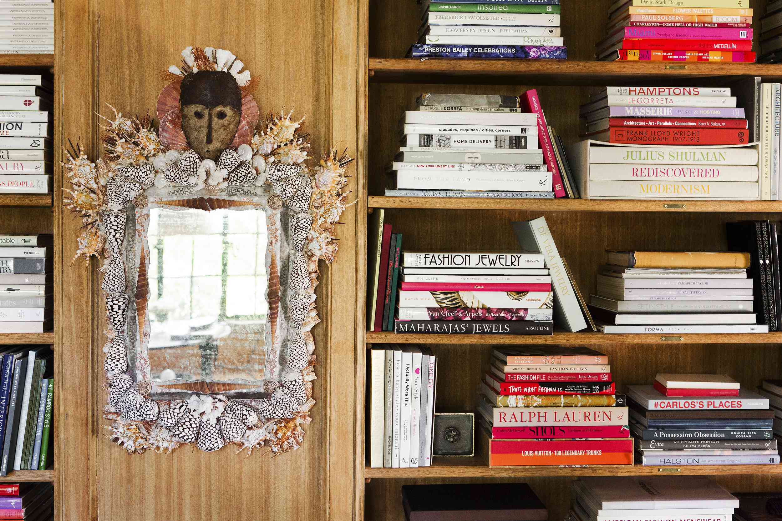 在一个折衷的空间里，有一个木制的嵌入式书架，还有一面装饰着贝壳的古怪的民间艺术镜子。
