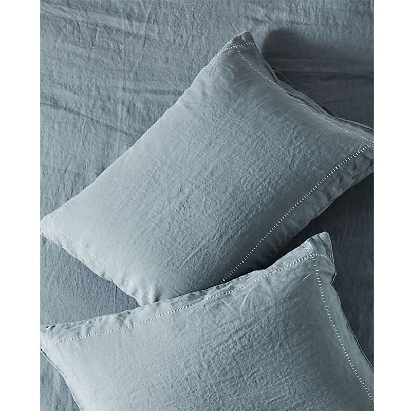 两个里面有枕头的蓝色亚麻布被子。