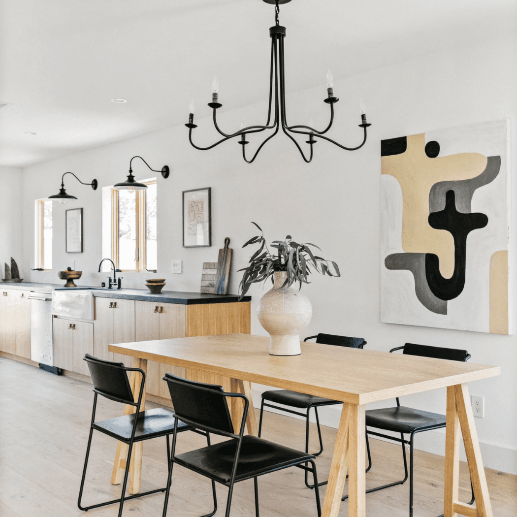 一个开放式概念用餐室，带黑色吊灯，坐标坐落在厨房里的灯光