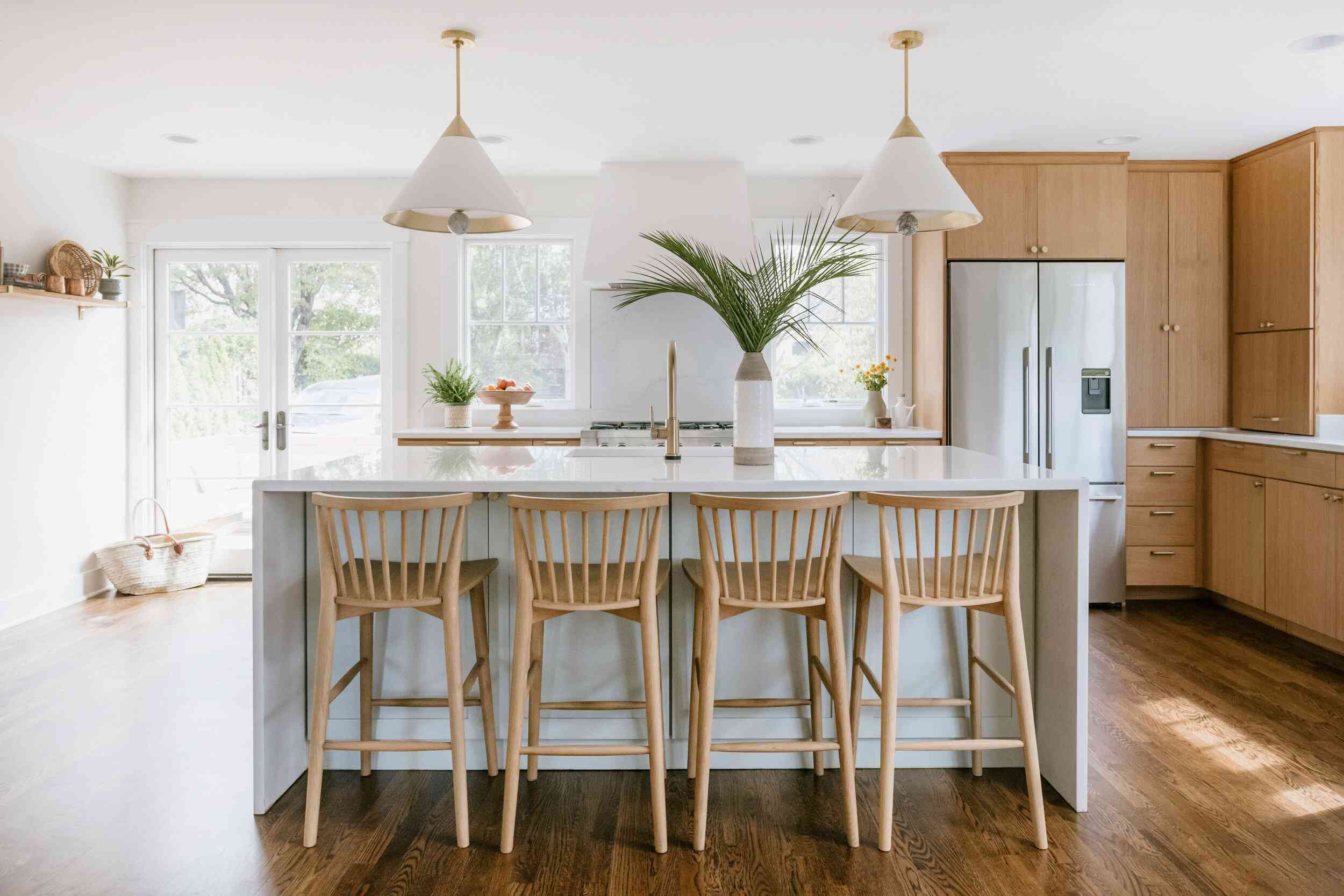 厨房里摆满了木制的橱柜、硬木地板和木制的酒吧凳