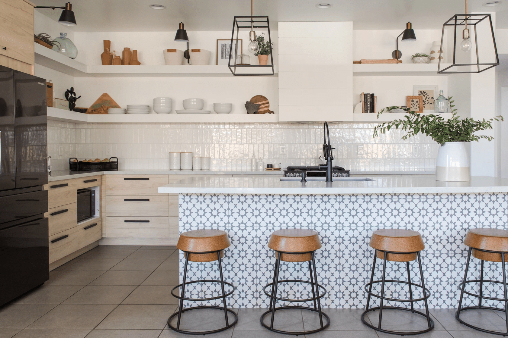厨房配有背板，带有白色瓷砖的衬托和厨房岛上衬有印刷瓷砖