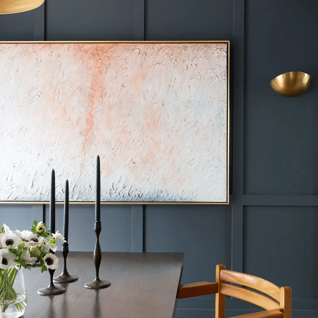 餐厅有一面靛蓝的墙壁，墙上挂着一幅浅粉色的画