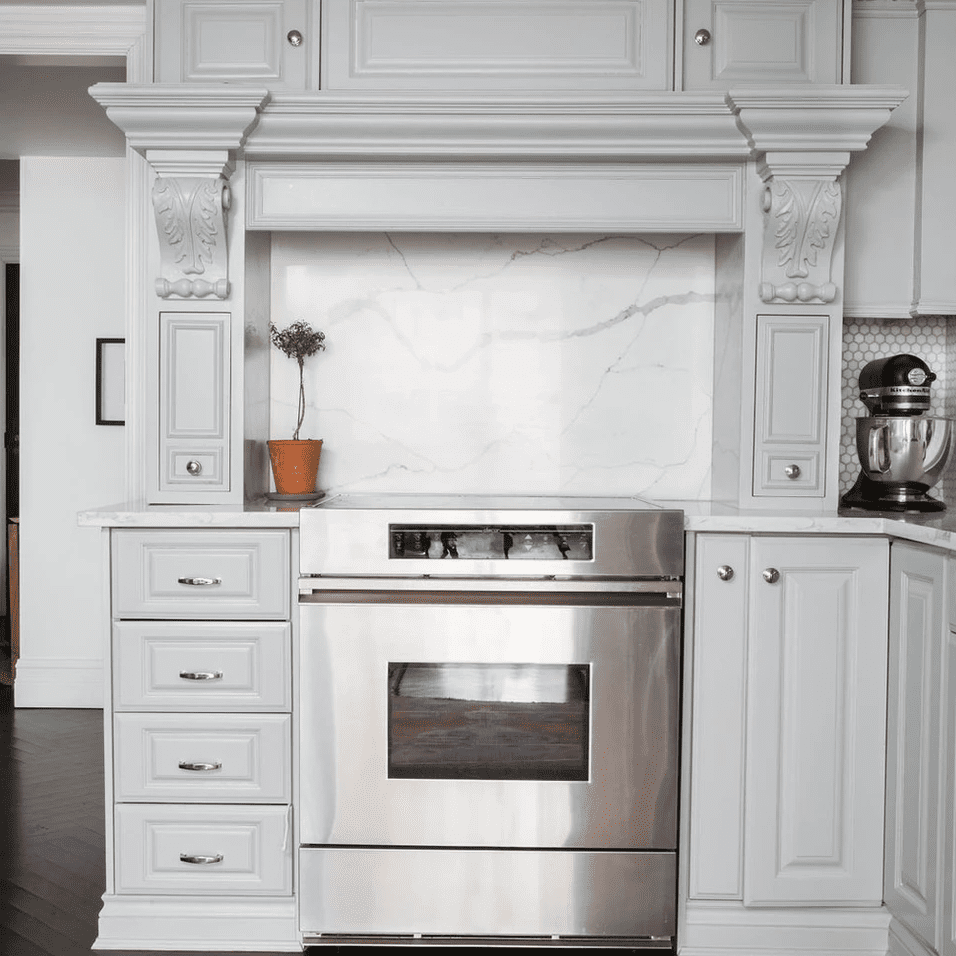 白色的小厨房，装饰着复杂的皇冠造型和装饰