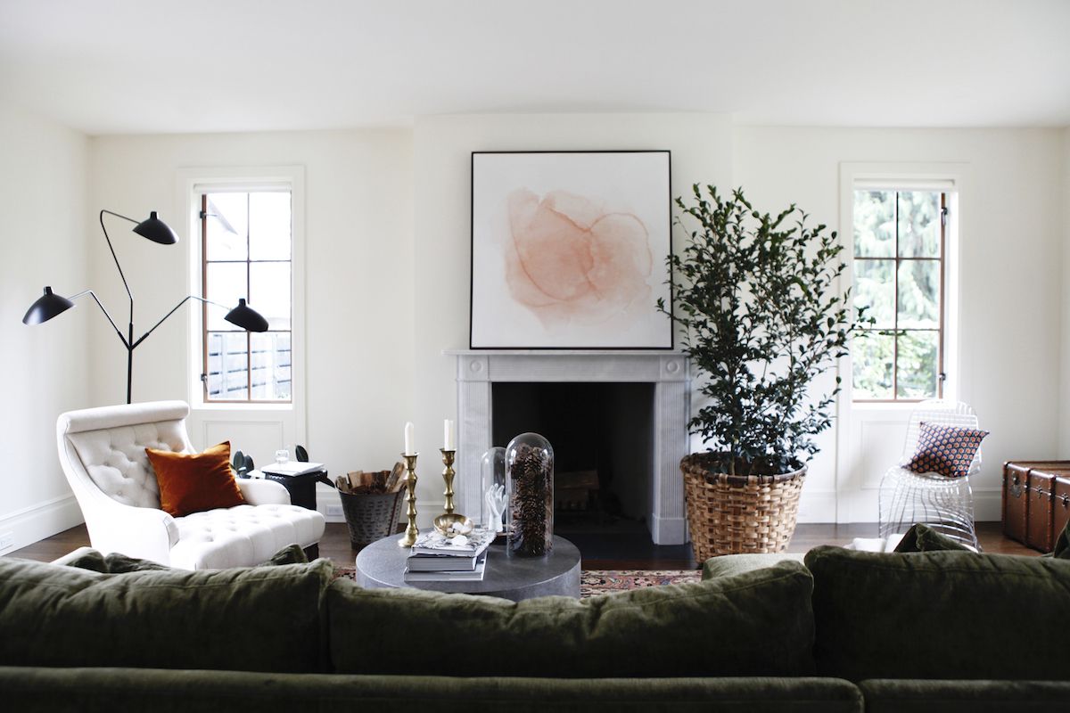 客厅里有一座浅灰色的大理石壁炉和现代艺术品