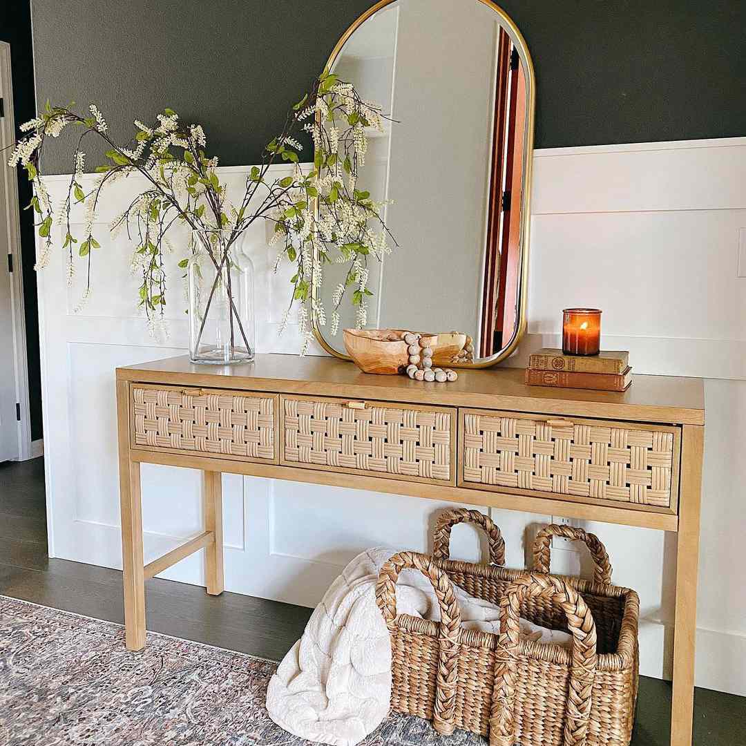 波西米亚风格的乡村入口餐桌与镜子和植物。