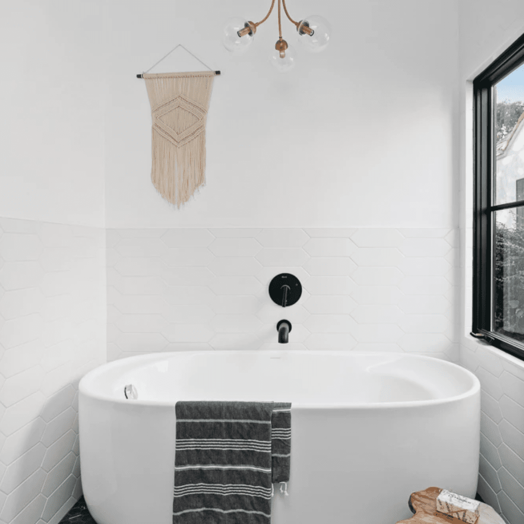 带白色浴缸和木炭瓷砖衬里楼层的浴室