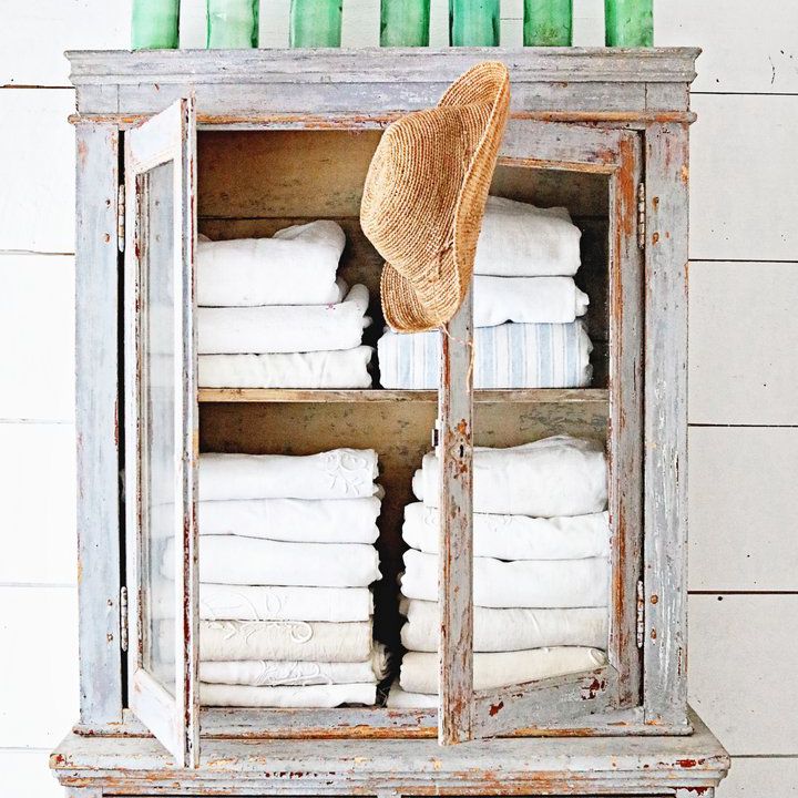 一个质朴的蓝色橱柜，上面有几个古董玻璃瓶